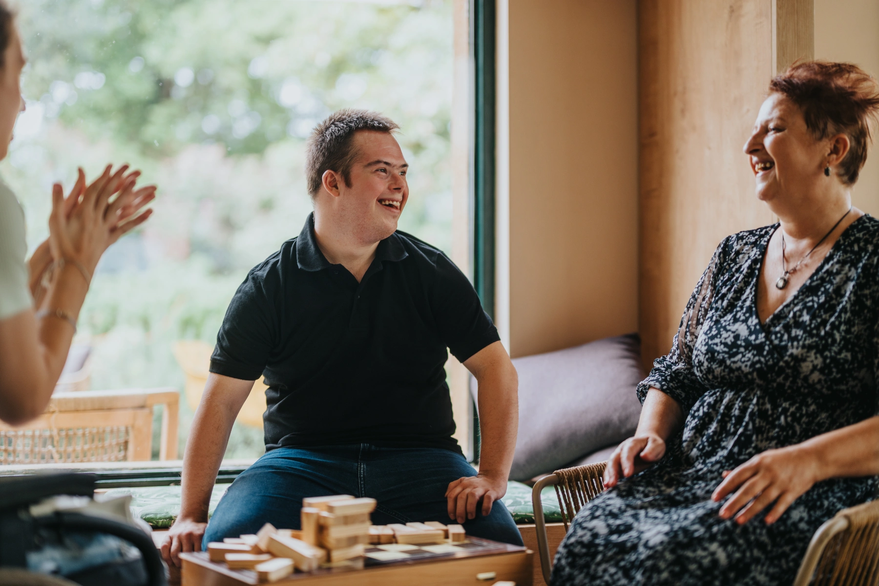 A joyful moment featuring a boy with Down syndrome, a girl in a wheelchair, and an elderly woman enjoying a building