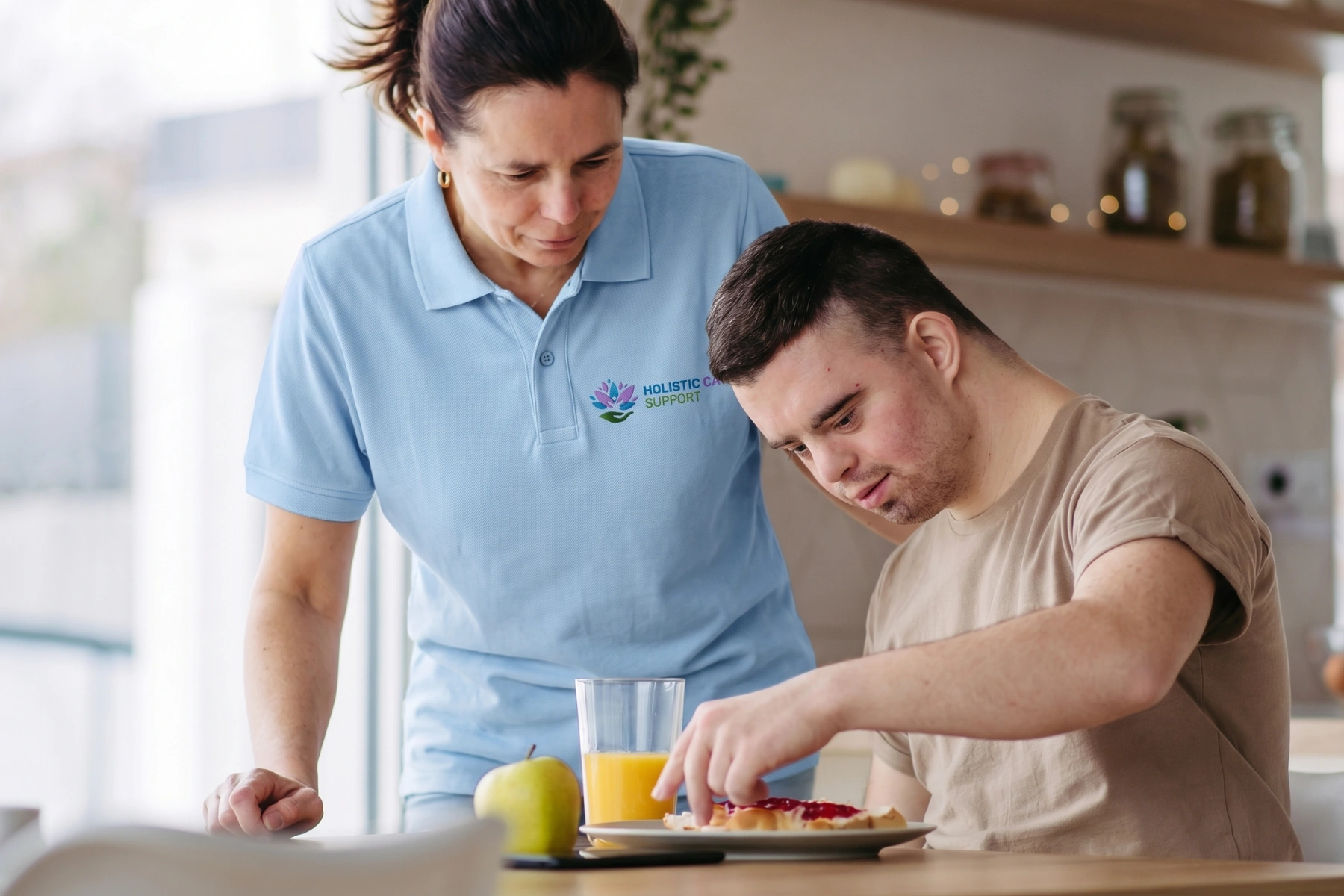 Young man with Down syndrome preparing breakfast with his mother at home. Morning routine for man with Down synd