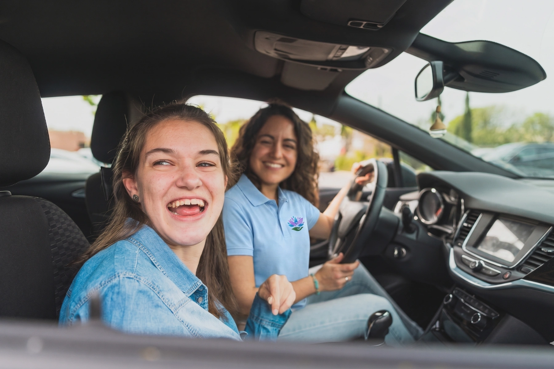 Young woman with cerebral palsy and assistant sharing joyful moment in car - Both smile warm
